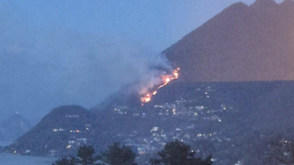 Vasto incendio nei boschi sopra Laveno: la lingua di fuoco visibile dal Verbano